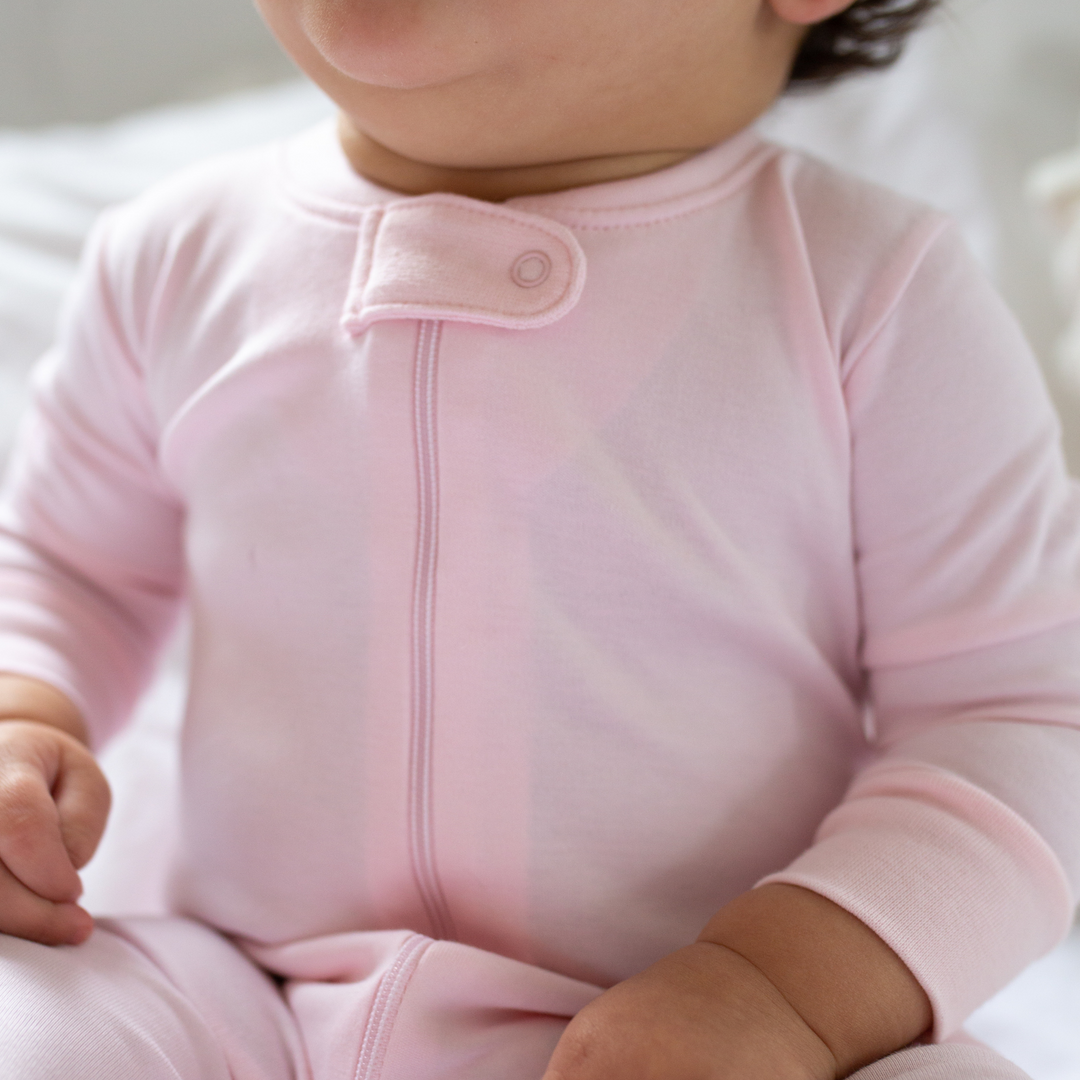 a baby wearing Zipper Romper in Light Pink 
