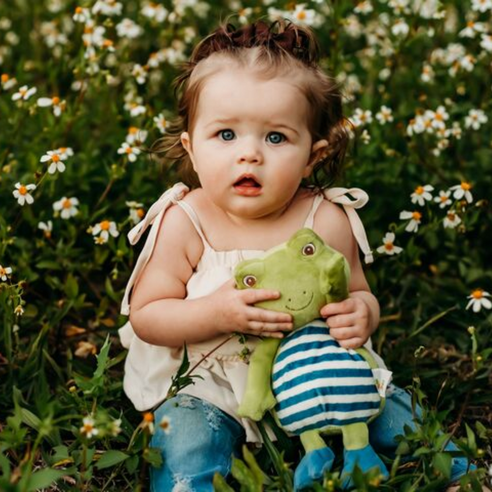 a baby girl holding the Tadbit Froggie