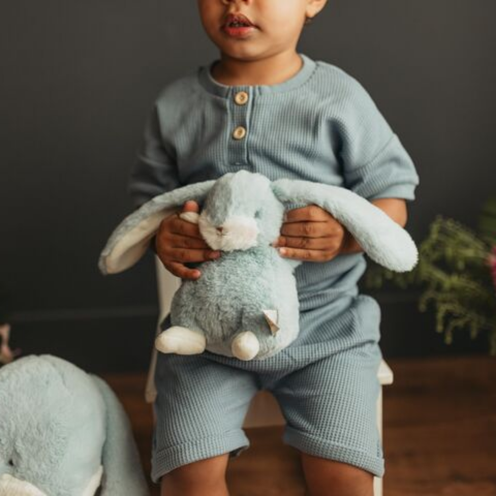 a boy holding the Tiny Nibble Bunny in Maui Blue