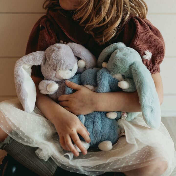 a girl holding the Tiny Nibble Bunny in Stormy Blue