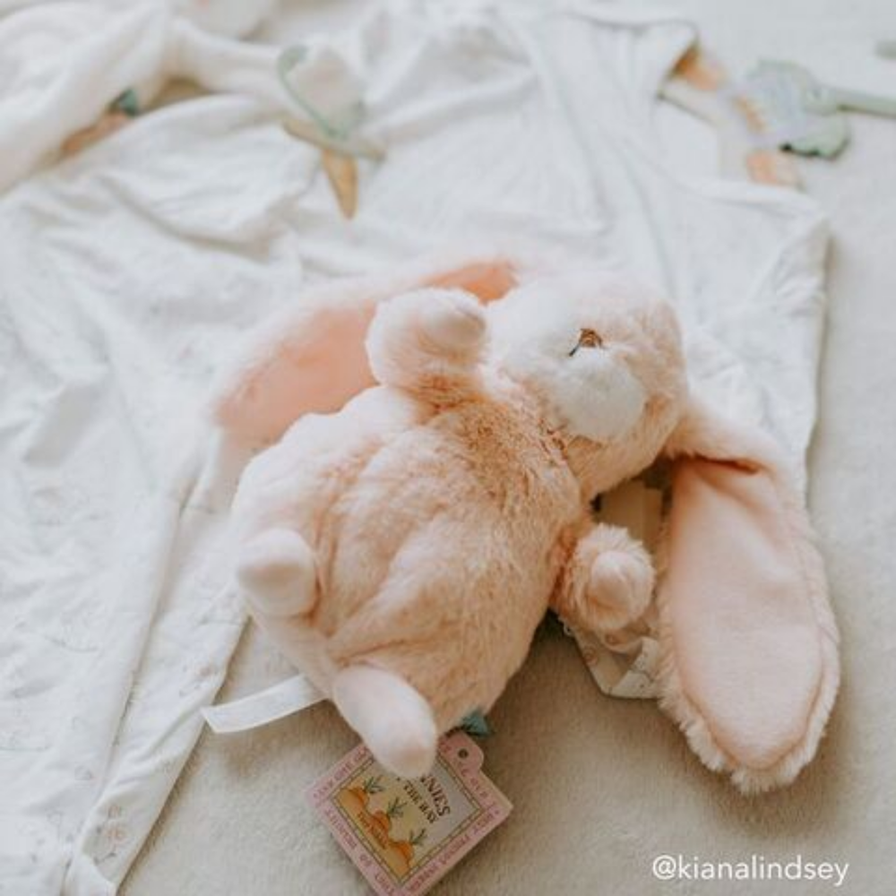 Tiny Nibble Pink Bunny lying in a bed