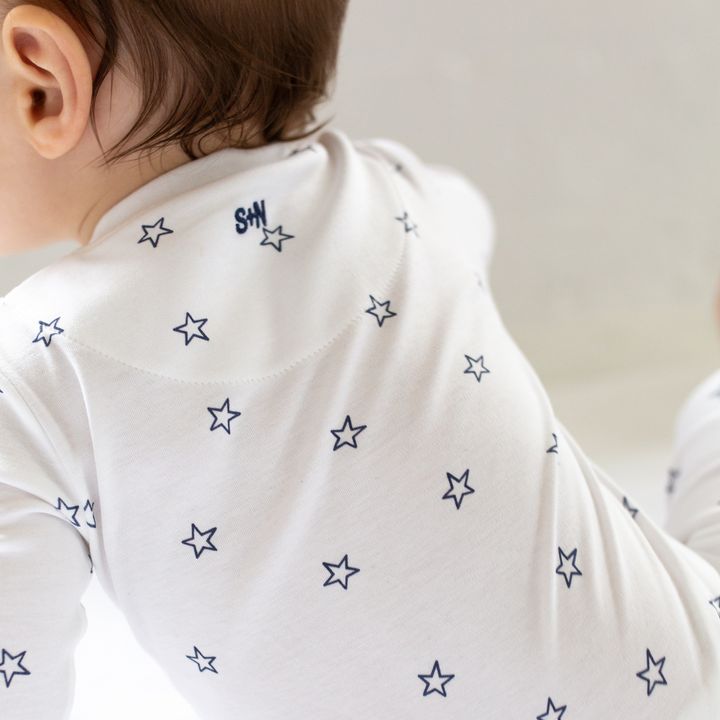 a baby wearing Tiny Stars Zipper Romper in Navy