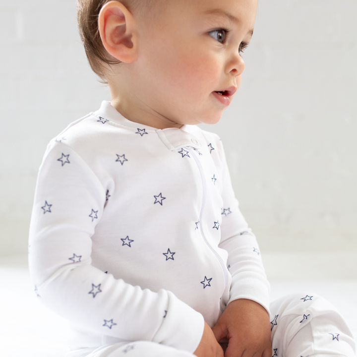 a baby wearing Tiny Stars Zipper Romper in Navy