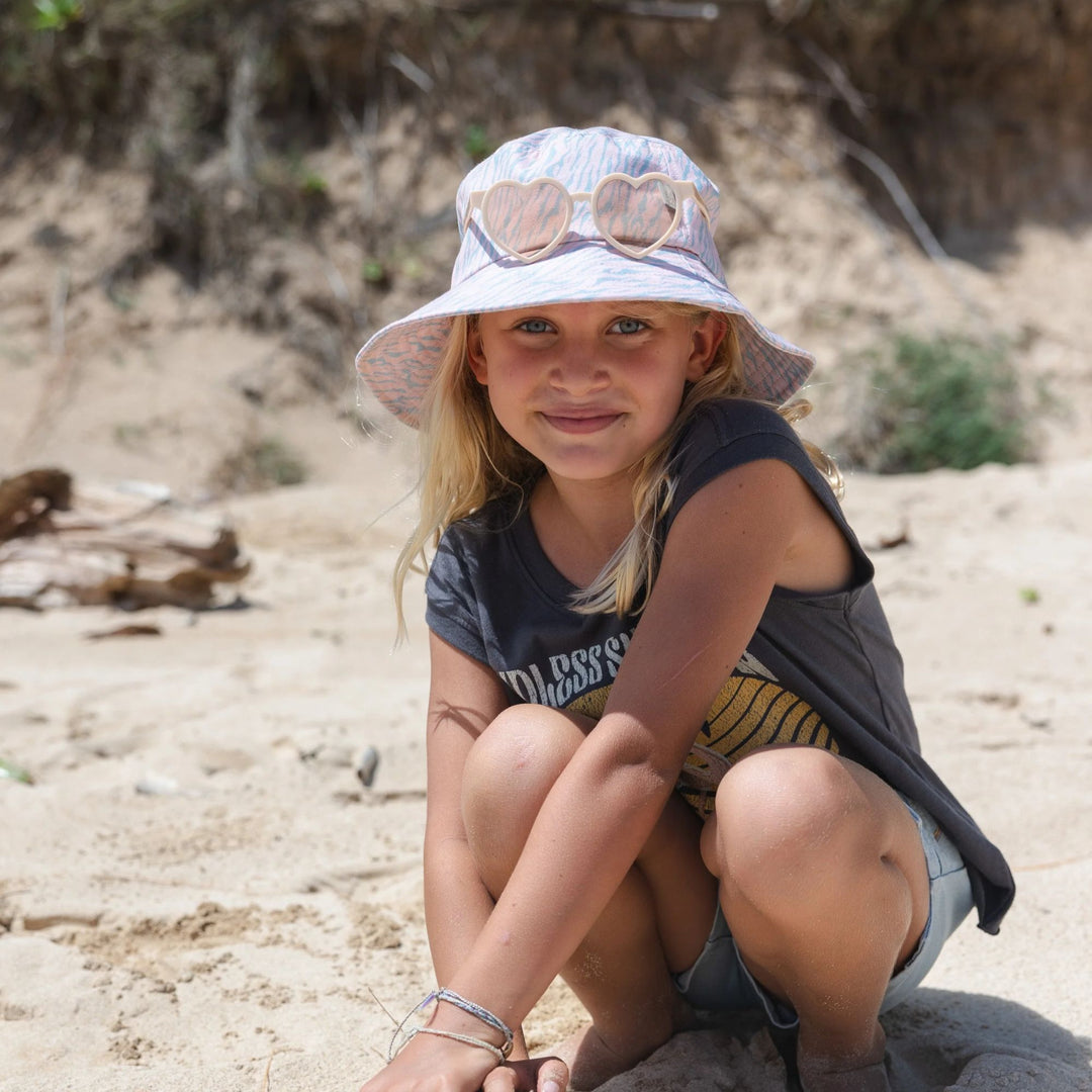 a girl wearing Wild One Bucket Hat in Pink/Seaglass