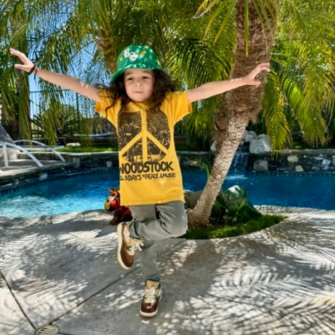 a little boy wearing Woodstock Short Sleeve Tee in Sunset