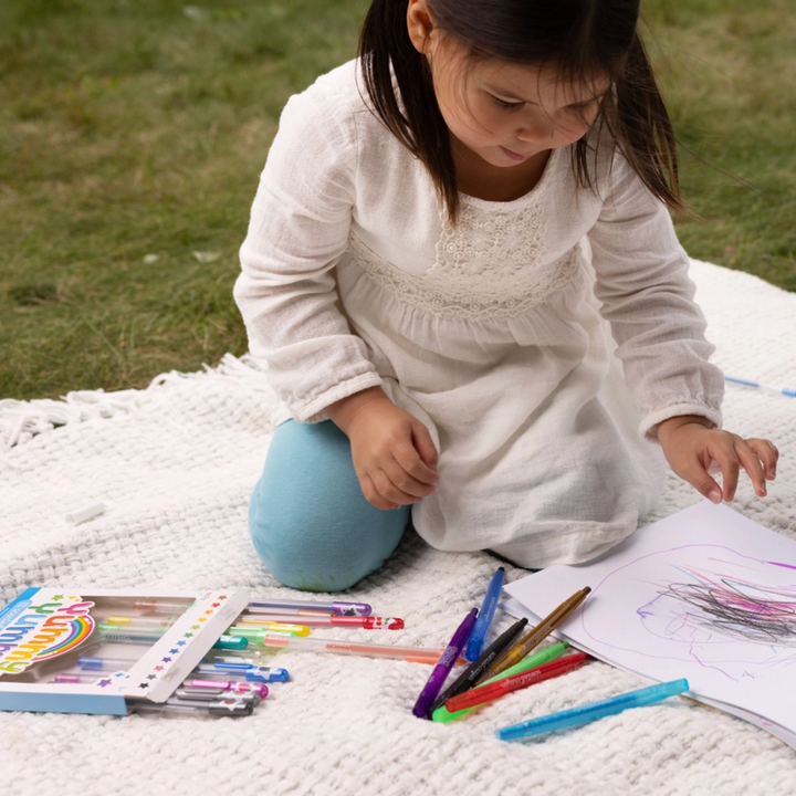 a little girl drawing using Yummy Yummy Scented Glitter Gel Pens