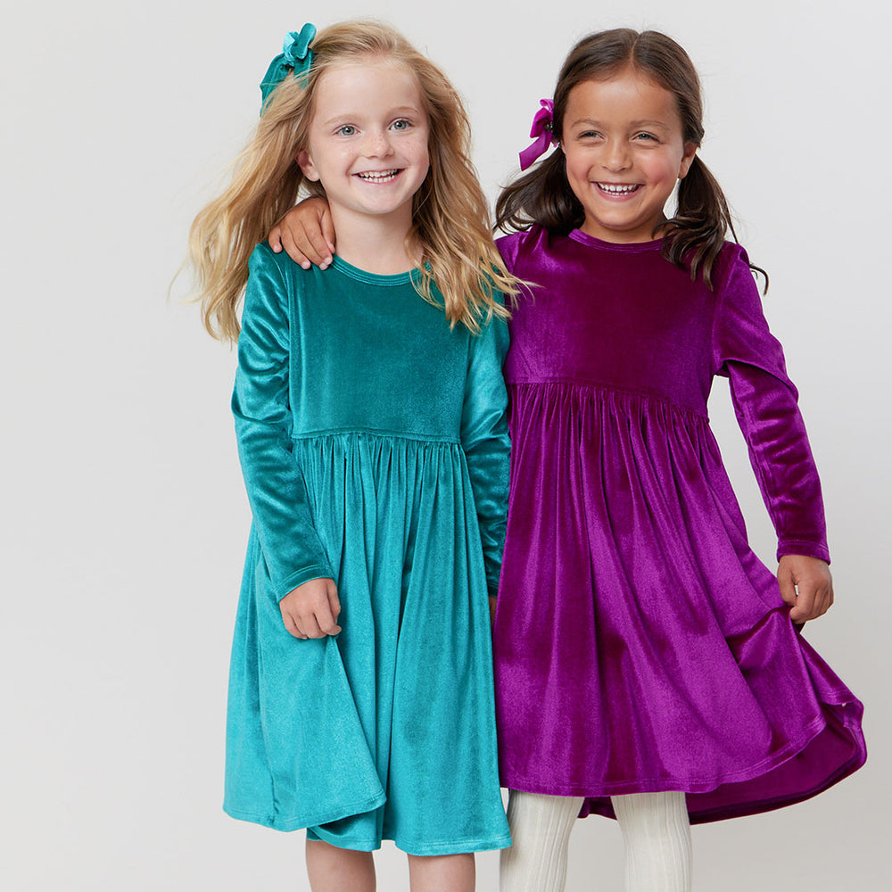 girls wearing velour dresses in green and pink