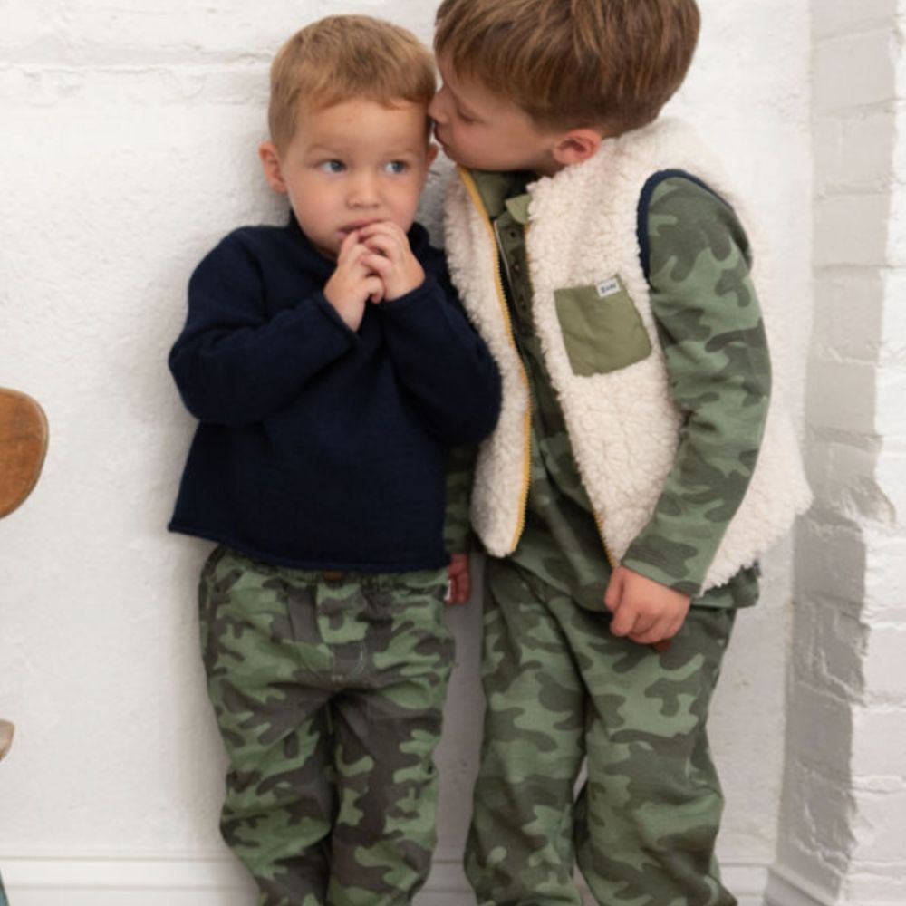 boy wearing sherpa vest and boy wearing blue sweater 