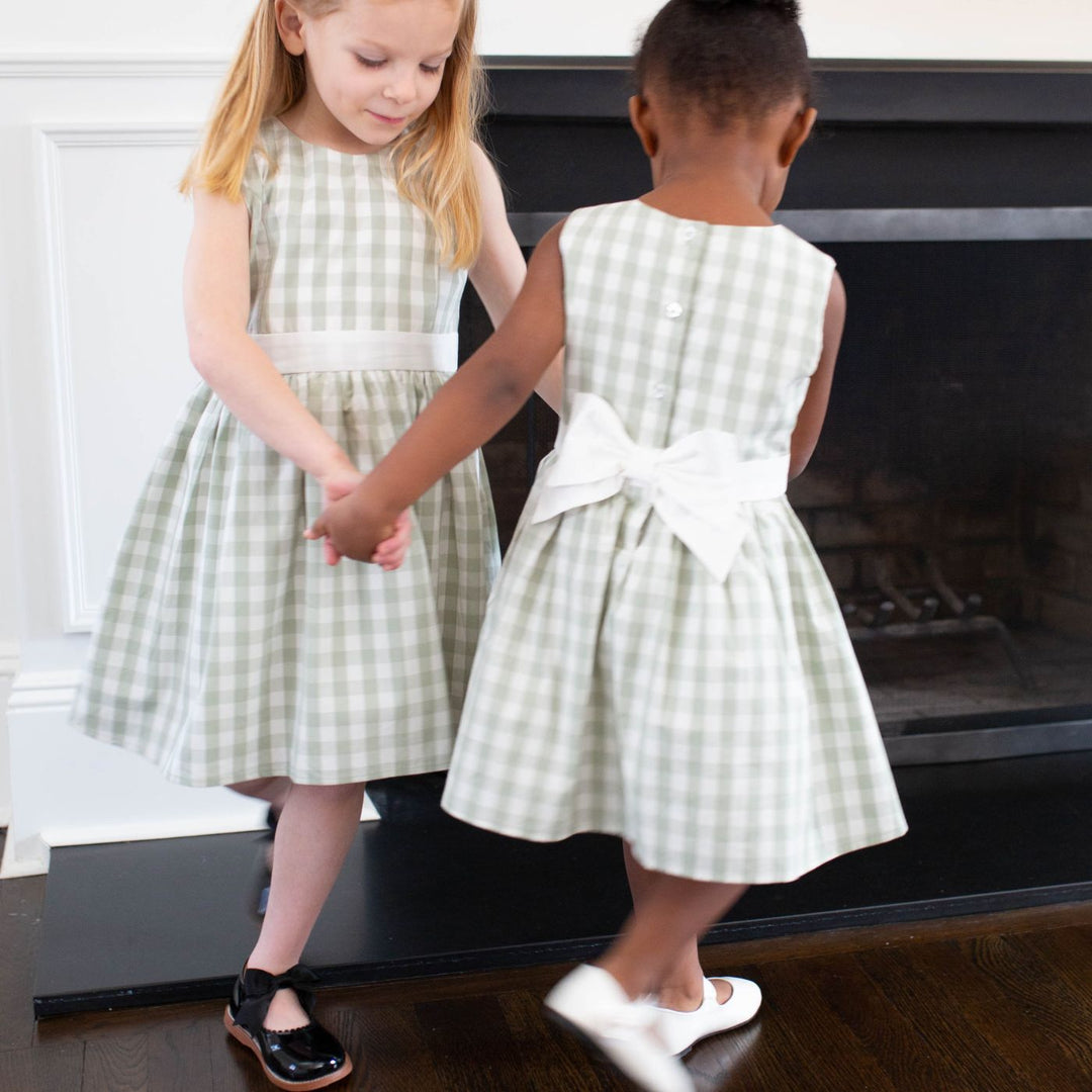 two girls holding hands wearing dress