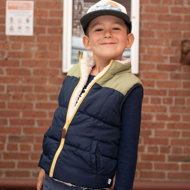 boy wearing blue vest