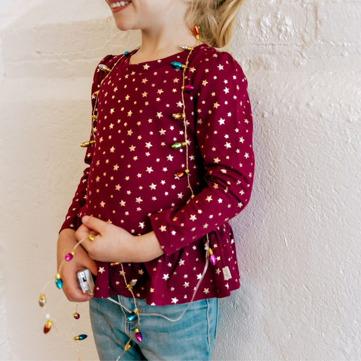 girl wearing red shirt with gold stars