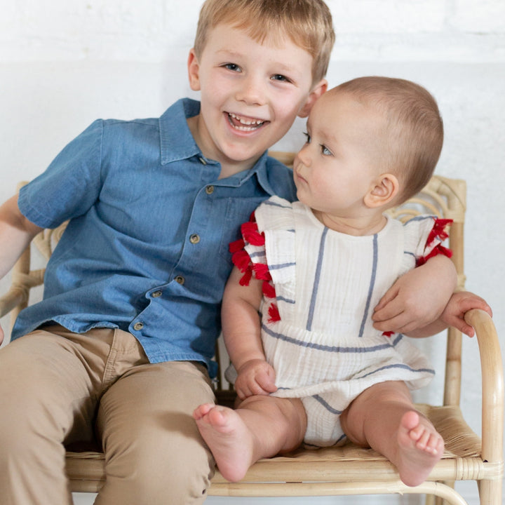 boy wearing chambray buttondown with baby wearing striped bubble