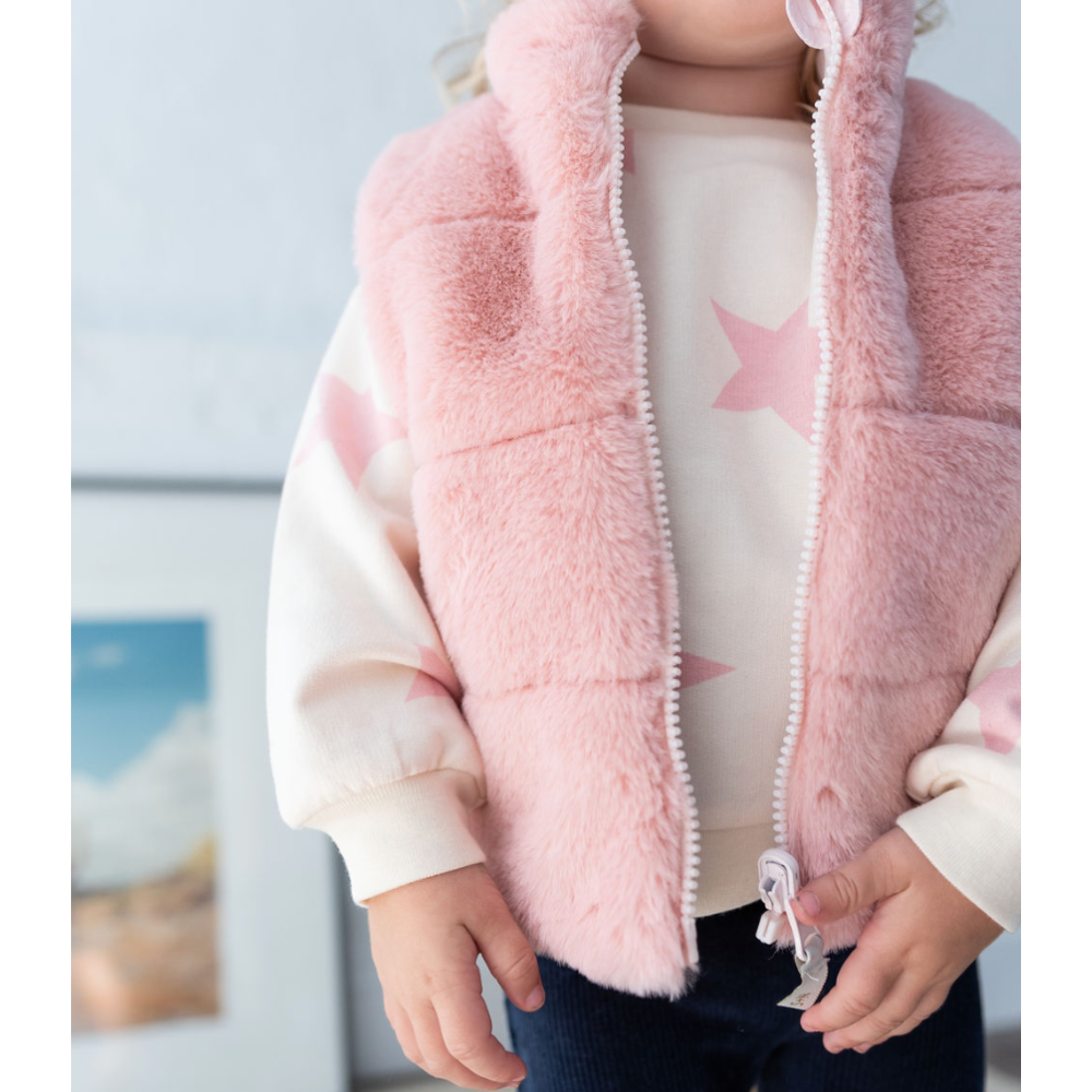 girl wearing star sweatshirt fur vest