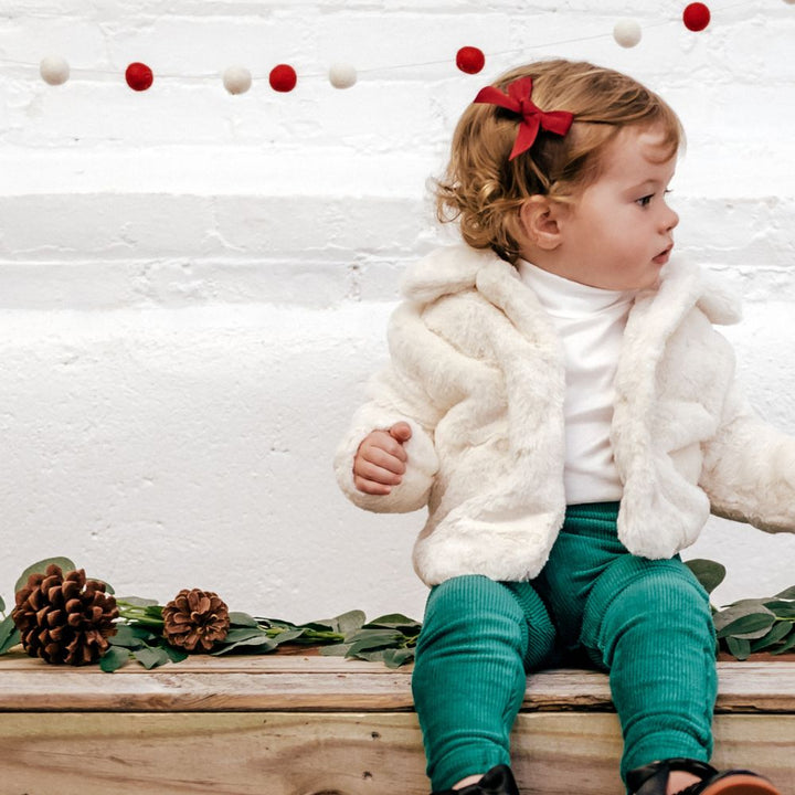 little girl wearing green leggings fur coat