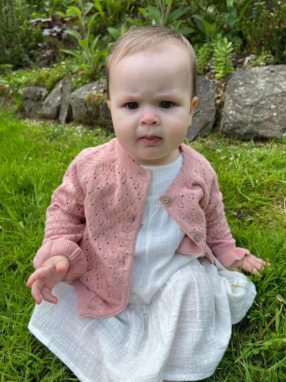 baby wearing pink cardigan
