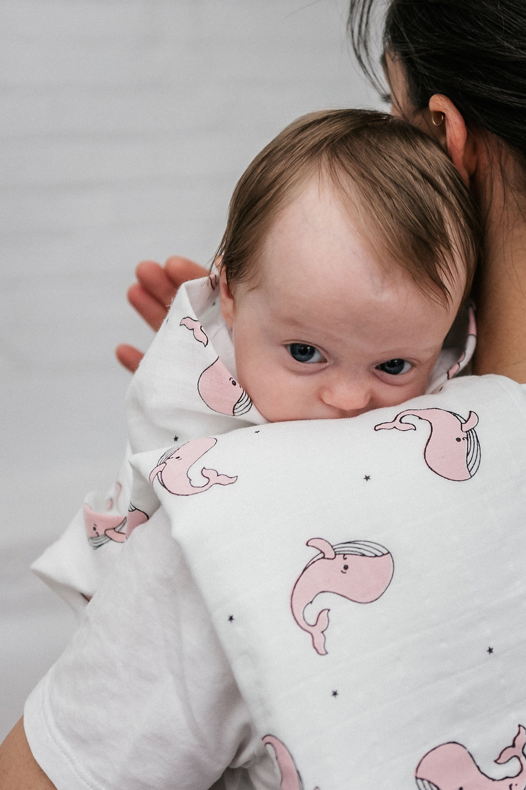 a baby and a mother using Organic 2-Pack Muslin Burp Cloth in Pink Whale