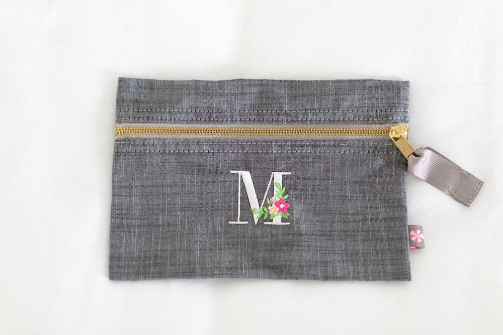 grey pouch with monogram