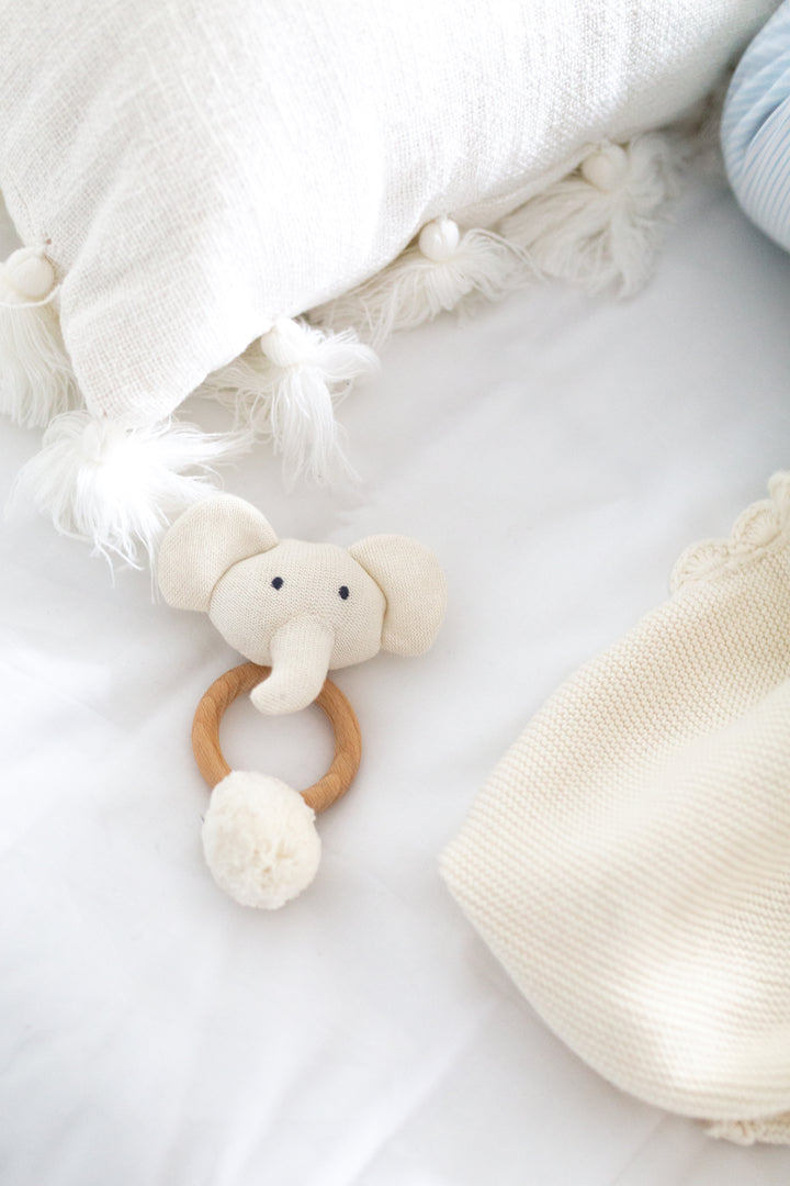 white elephant rattleOrganic Knit Elephant Rattle in White in a bed