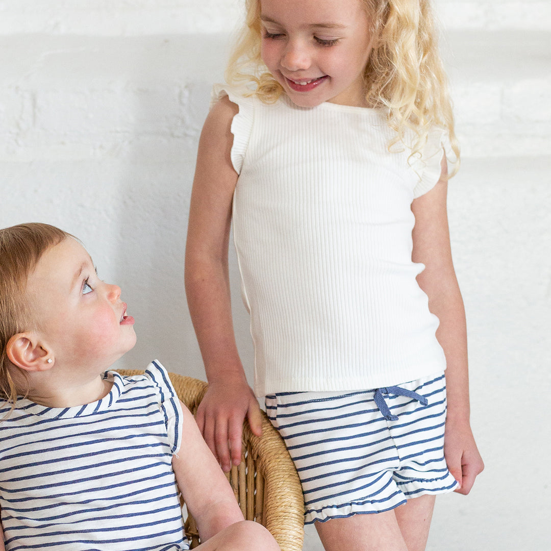 girl wearing white tank and navy striped shorts