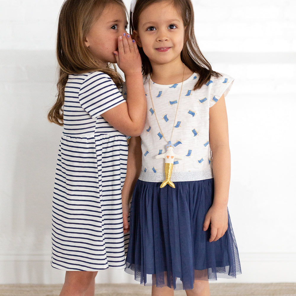 two girls wearing striped and. beach chair dresses