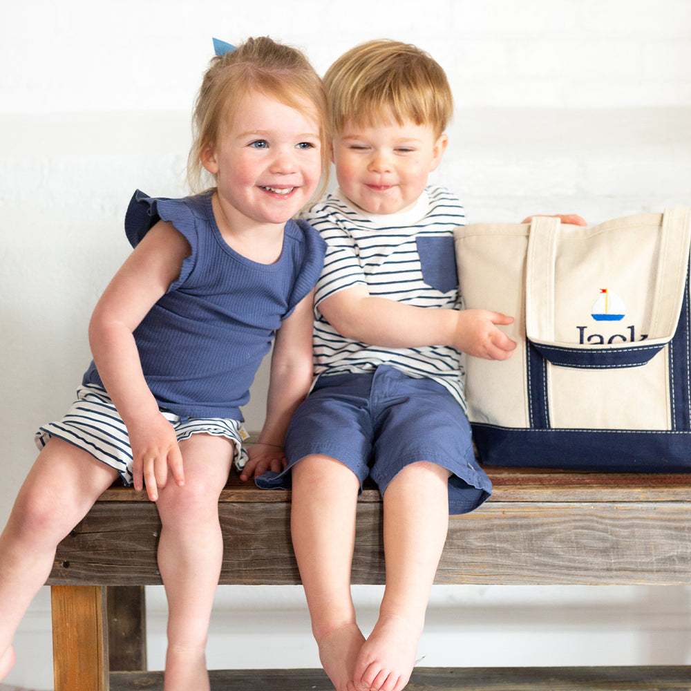 two kids on bench in navy tank top and striped shirt