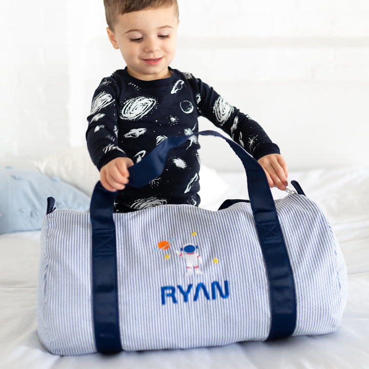 boy with blue duffle bag with. monogram