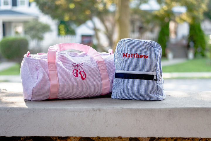 pink duffel bag, blue backpack