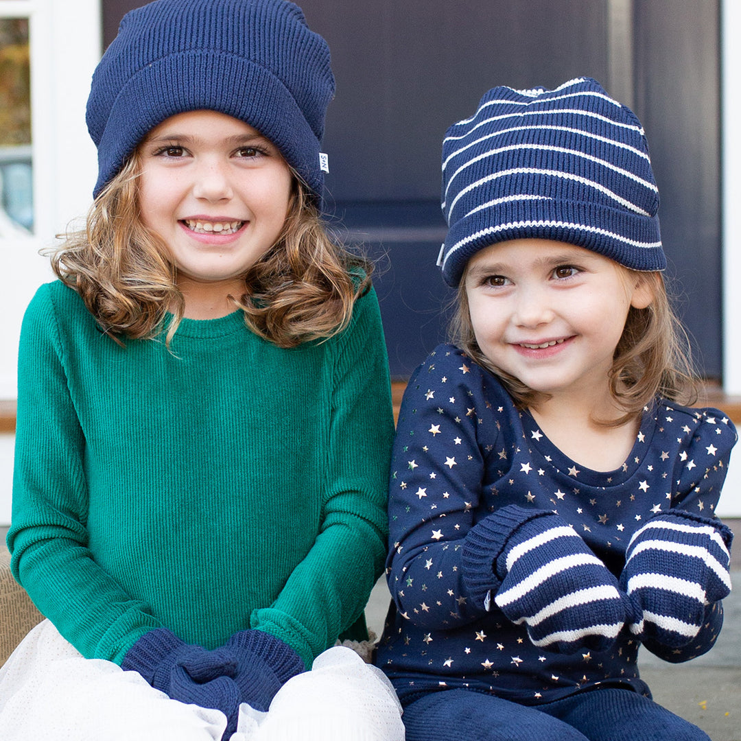 two girls wearing navy winter hats and gloves